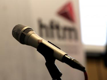 Diplomfeier Techniker HF Biel - Mikrophon vor hftm Logo