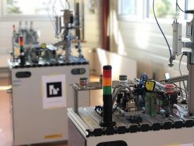 Robotino Roboter mit Station im Hintergrund