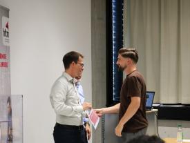 Person der Gewinnergruppe bekommt die Urkunde