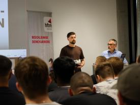 Studenten präsentiert ihr Projekt und eine Person steht daneben